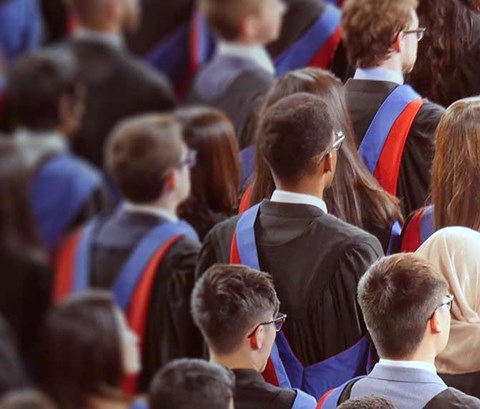 a large group of students in robes at a graduation ceremony