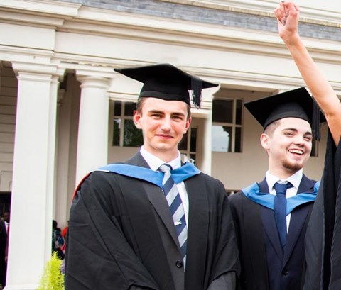Graduates posing for a picture outside DeMontfort Hall