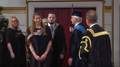 Students on stage with vice chancellor at graduation ceremony