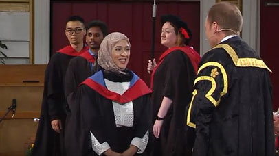 Student on stage with vice chancellor at graduation ceremony