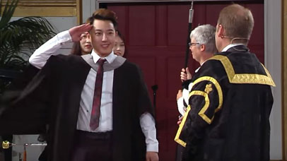 Student saluting vice chancellor at graduation ceremony