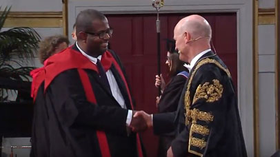 Student shaking chancellor's hand at graduation ceremony
