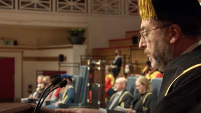 Person speaking on stage at graduation ceremony