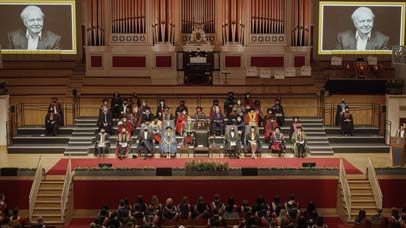 Long shot of people on stage at graduation