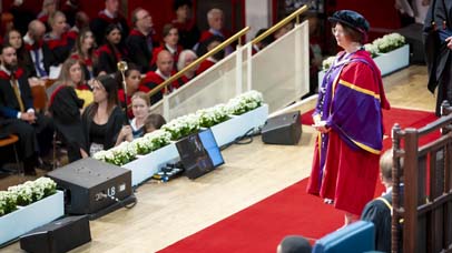 Lady in a robe looking on from the stage