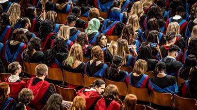 Graduands sitting in the ceremony within De Montfort Hall