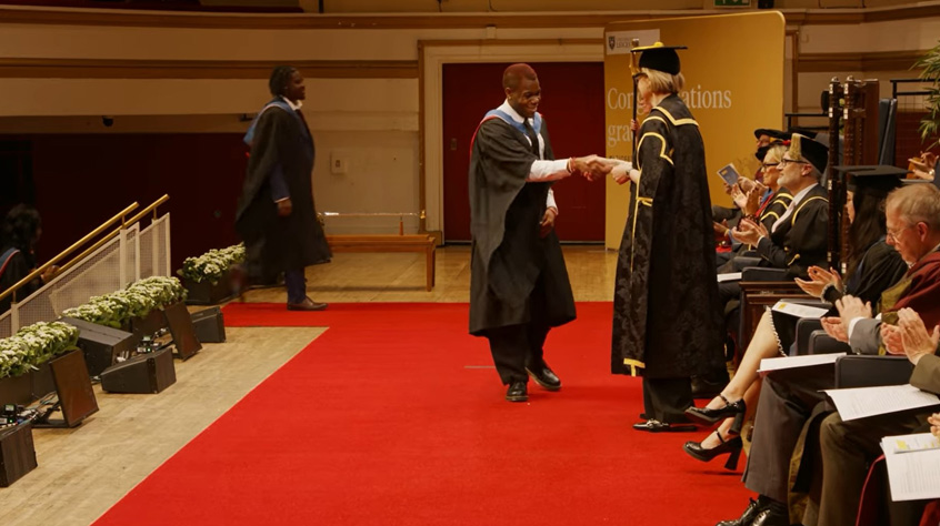 University of Leicester Graduand shaking hands with Professor Henrietta O’Connor as he crosses the stage at the 1.30pm ceremony at DeMontfort Hall