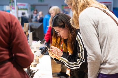 visitors inspecting an item with magnifying glass and phone