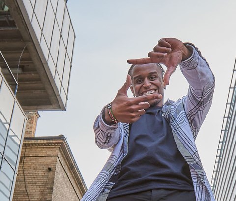 Student looking at the camera and making a square with his fingers