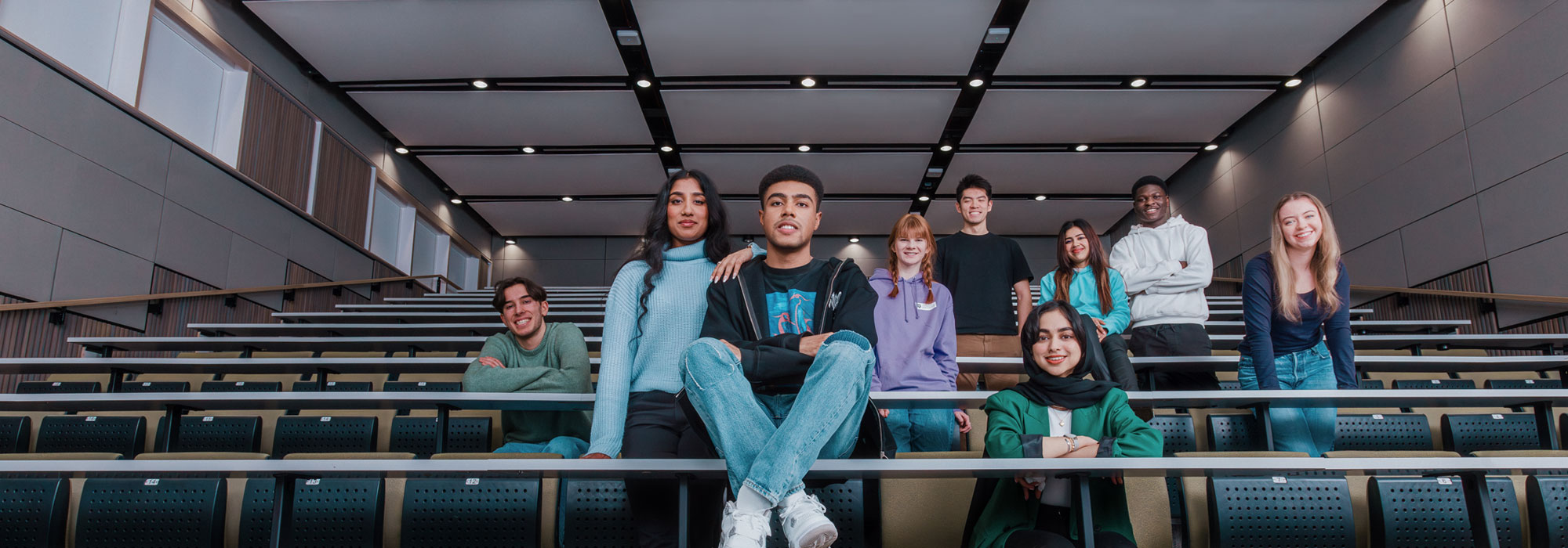 Students from different ethnic backgrounds sitting in a lecture theatre. 