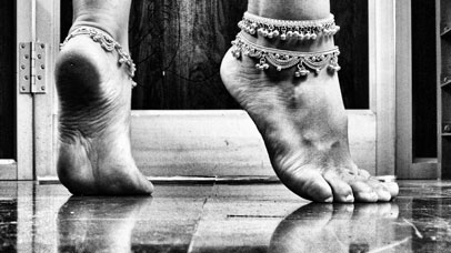 Close up of feet in a dancing pose wearing ankle bracelets