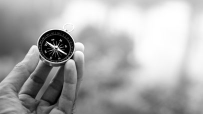 A hand holding a compass