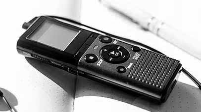 a dictaphone on an open notebook