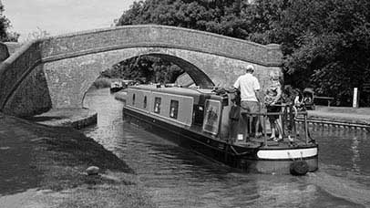 Canal boat going under a bridge