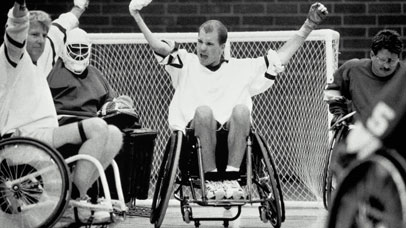 Wheelchair hockey players celebrating goal.