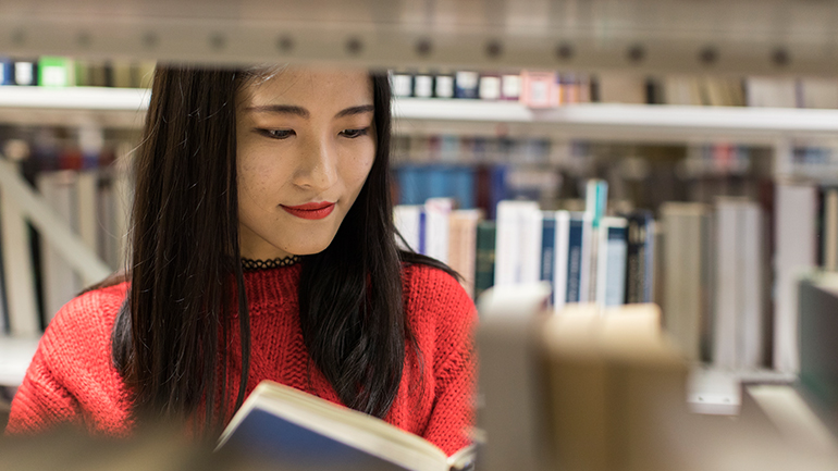 Student reading a book in the Library