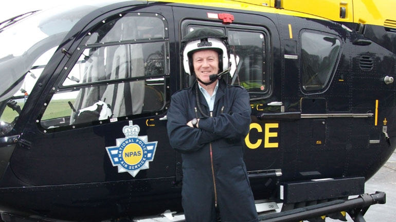 Dr Andrew Bennett standing next to a helicopter