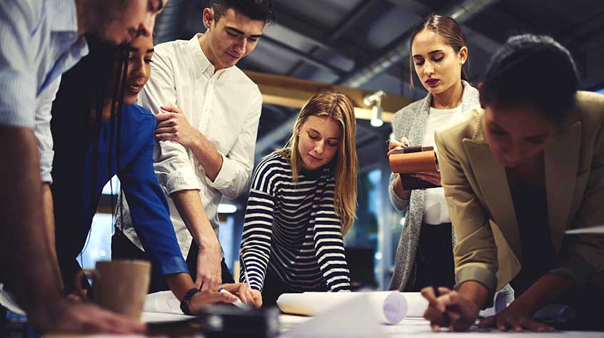 A group of people gathered around a table in an office environment