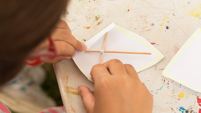 Child making a paper kite