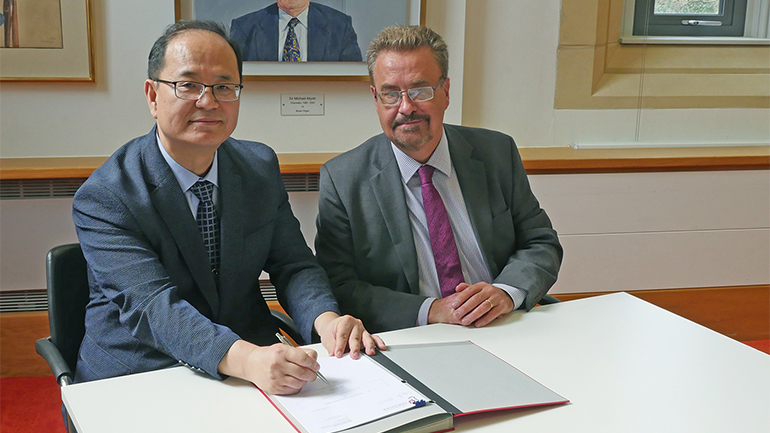 Professor Iain Gillespie signing a memorandum of understanding