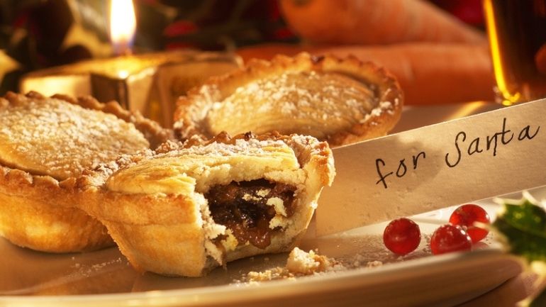 A plate of mince pies with a bite taken from one - includes the label 'For Santa'.