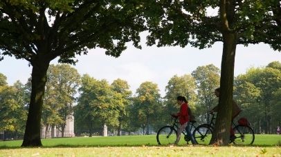 Two cyclists framed by trees in Victoria Park, Leicester.
