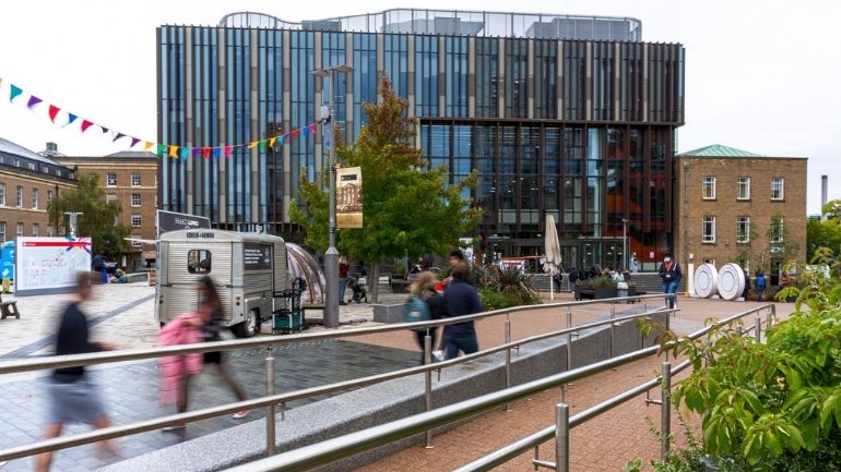 People moving on Centenary Square in front of the East Wing development of the Percy Gee Building.