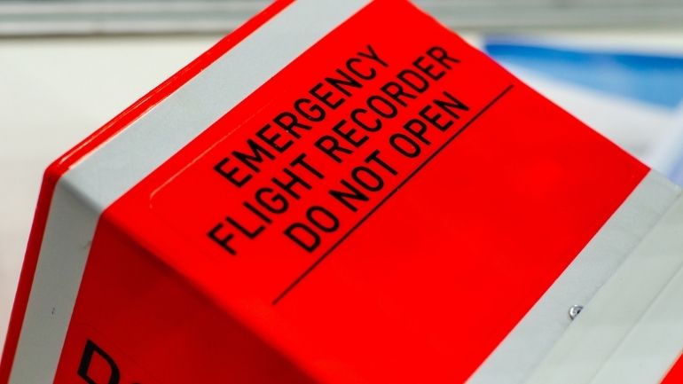 A bright orange Emergency Flight Recorder, with 'Do Not Open' printed on its front.