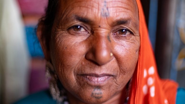 Close up of an Indian woman, looking straight down the camera.