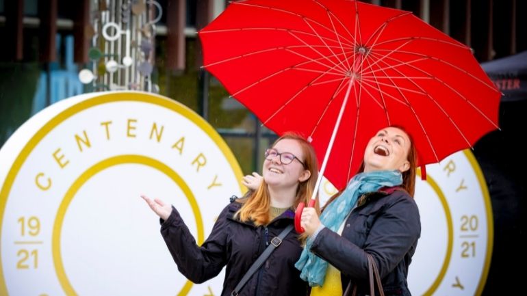 Two women under an umbrella at the University of Leicester's ChangeMakers Festival.