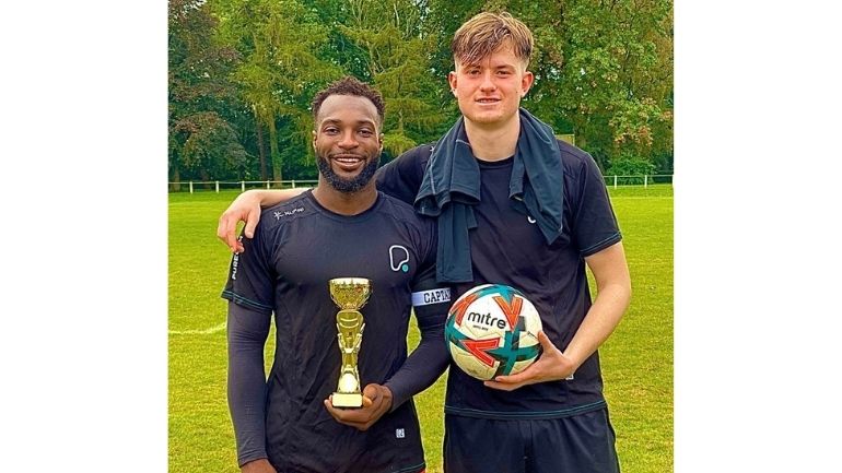 Fitness influencer Flexy Nyarko with Leicester student Daniel Serrano, holding a football and trophy.