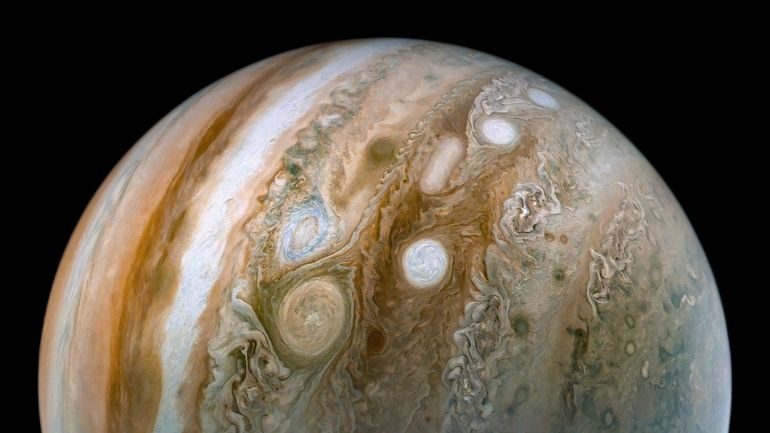 View of Jupiter, with vivid orange and white bands in its atmosphere and its famous 'Great Red Spot'.