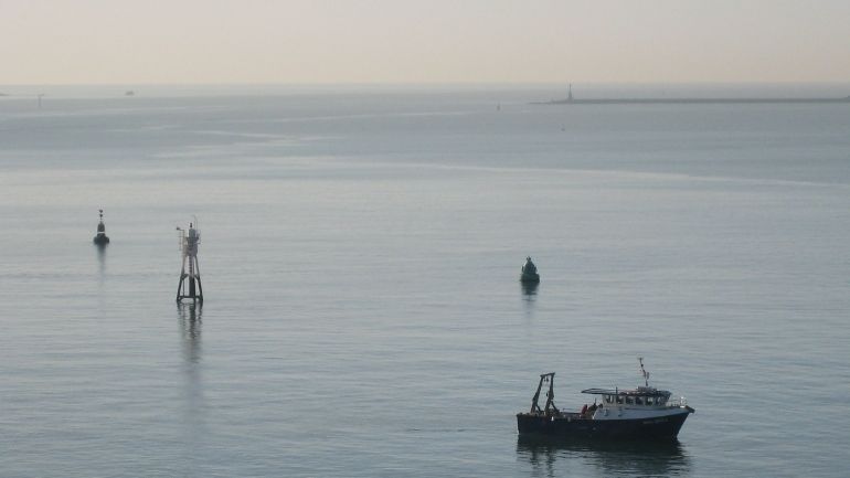 A small boat in Plymouth Sound at sunset.