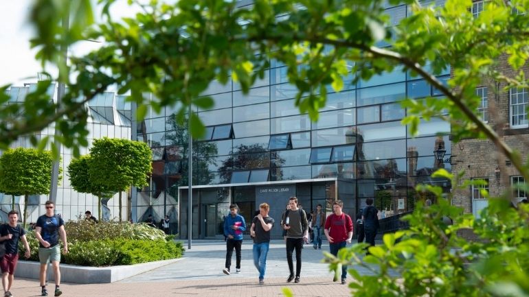 Students in front of the David Wilson Library on the University of Leicester campus.