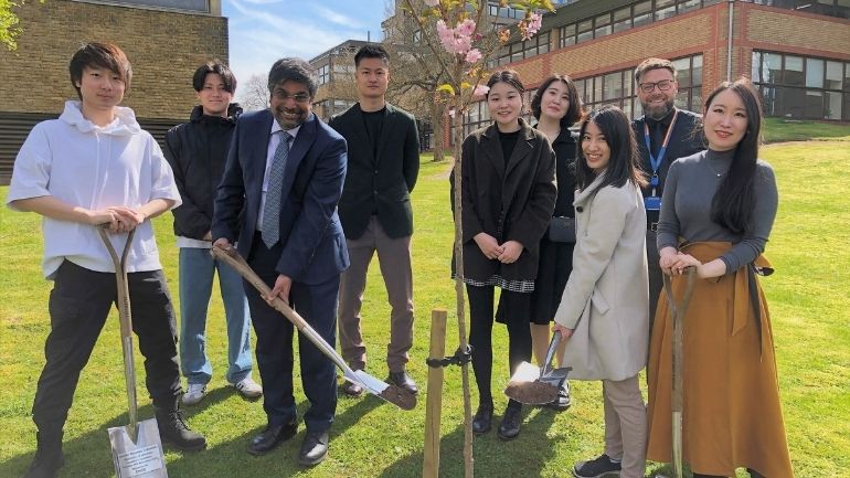 University of Leicester President and Vice-Chancellor, Professor Nishan Canagarajah, plants a Japanese cherry blossom tree with seven Japanese students.