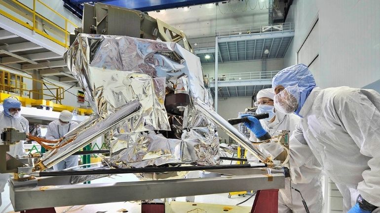 Two engineers in clean suits check MIRI ahead of flight at NASA's Goddard Space Flight Center.