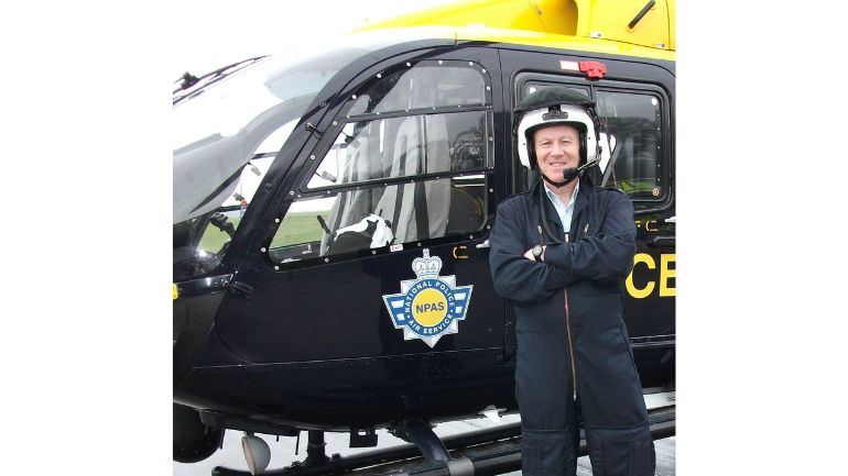 Dr Simon Bennett in flight suit and helmet ready to climb aboard an NPAS helicopter.
