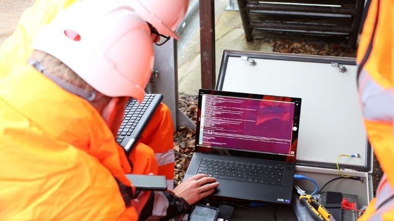 A University of Leicester researcher and Synoptix engineer check installation of the OPTIMUS prototype using a laptop.