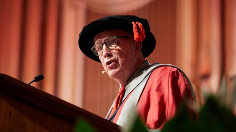 Tom Robinson speaks from the University lectern as he is bestowed an Honorary Degree.