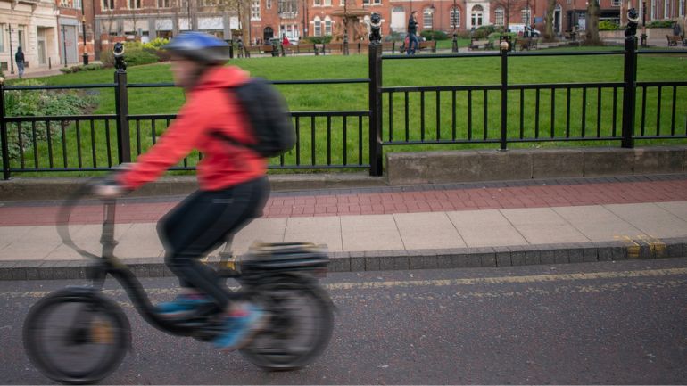 A cyclist in Leicester, wearing an air quality sensor on their back.