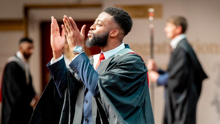 A University of Leicester graduate blows a kiss to the crowd as he is awarded his degree.