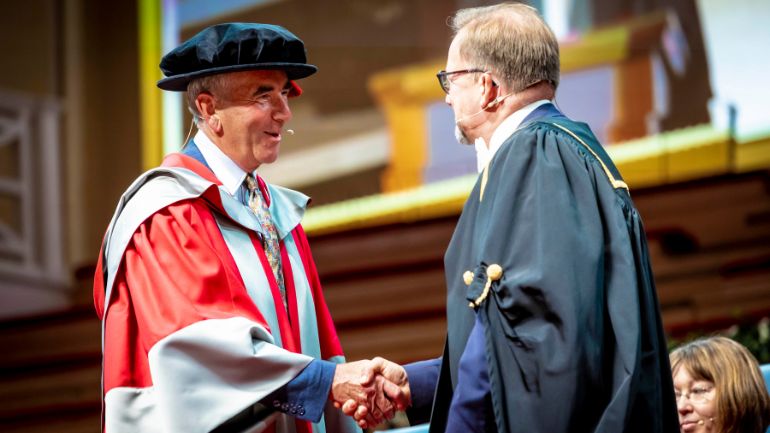 Robert Harris collects his honorary doctorate.