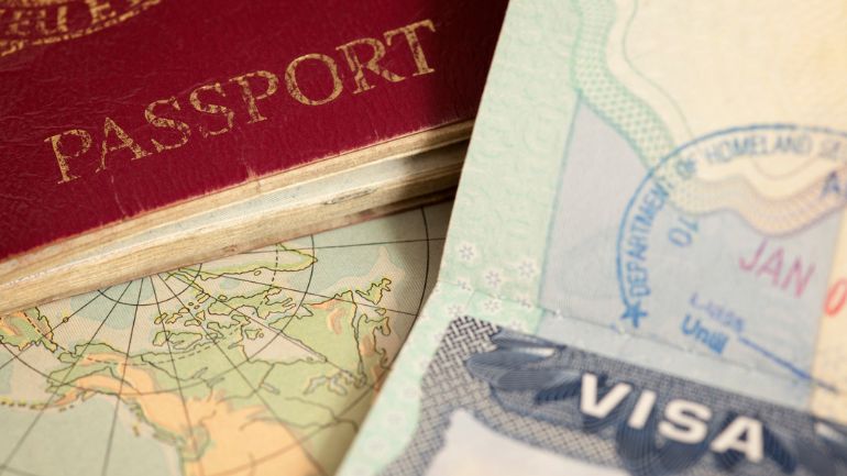 A passport and visa placed on a world map.
