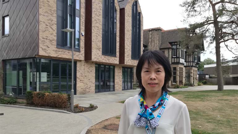 Dr Wen Wang standing outside University of Leicester School of Business