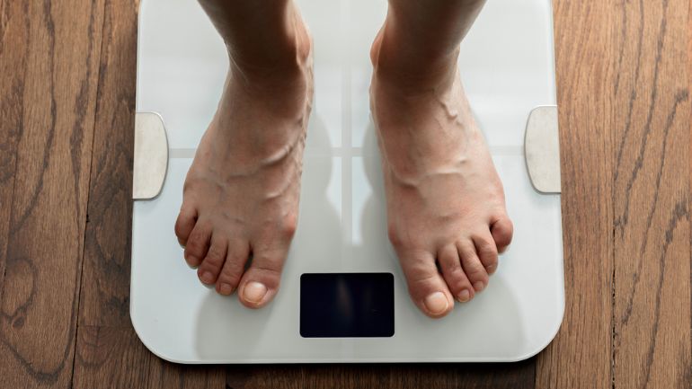 A person stood on weighing scales.