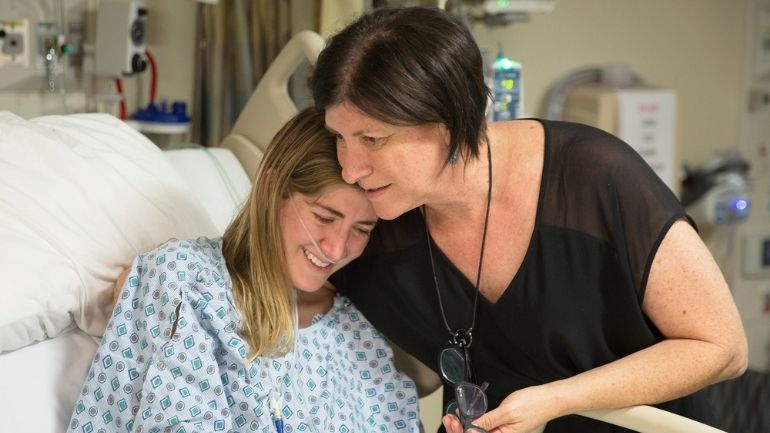Family photo of Mallory Smith on a hospital bed with her mother, Diane Shader Smith.