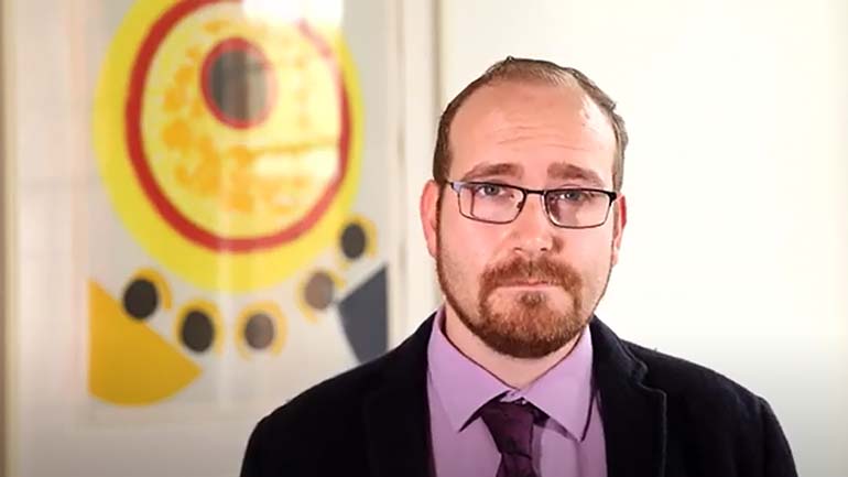 Dr Bleddyn Bowen from the School of History, Politics, and International Relations wearing a suit and glasses