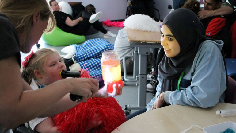 A young person enjoys a sensory experiment.