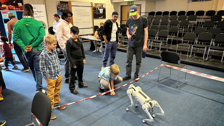 A very warm interaction between a young visitor and the robot dog.