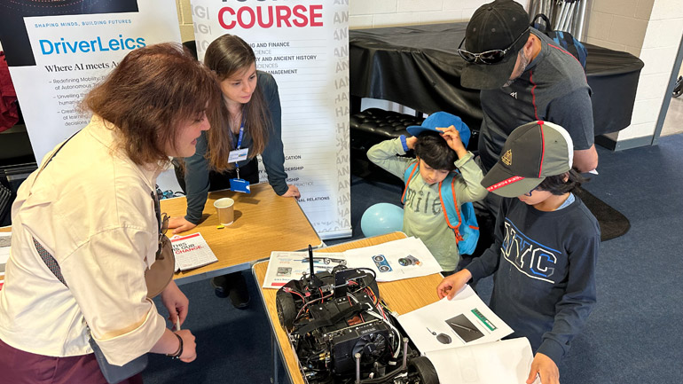 Genovefa and Neslihan show visitors self-driving car.